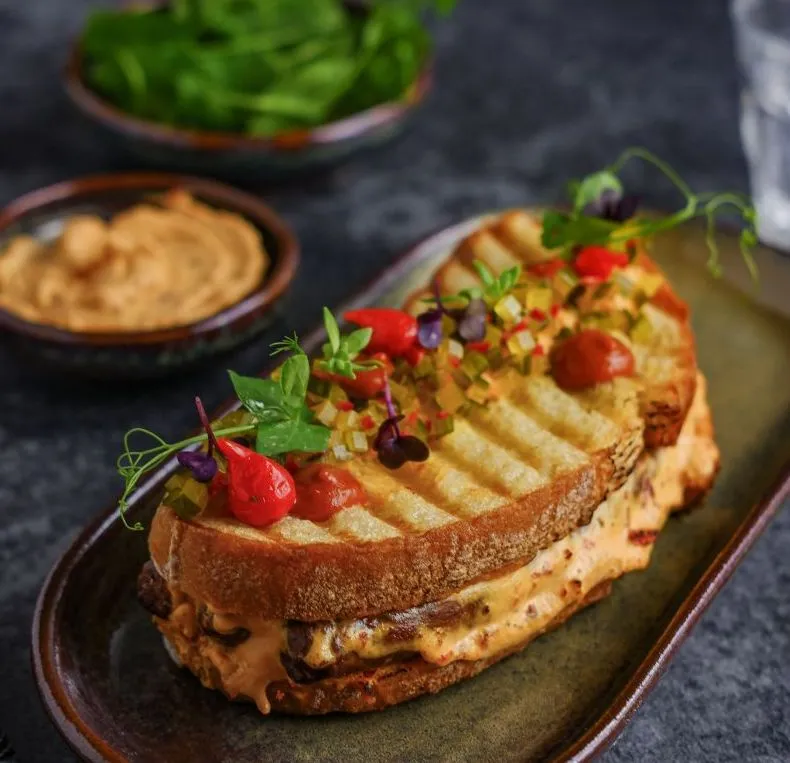 Croque Merqueze met hummus en zoetzure komkommer