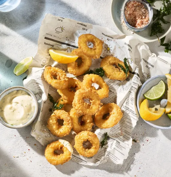 Vegan Calamares ringen op een bord met dipsaus en citroen