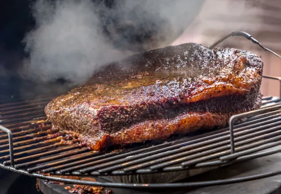 Groot stuk vlees op barbecue met rook
