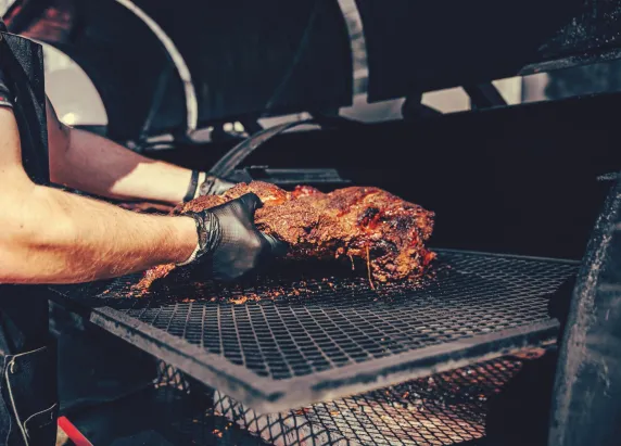 Chef legt groot stuk vlees op barbecue